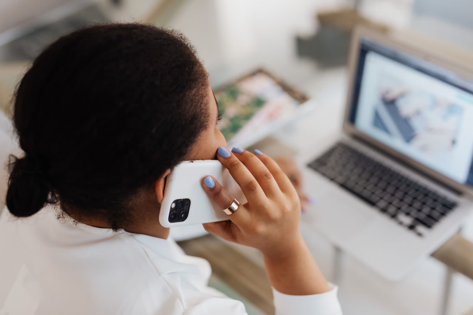 Iemand aan een bureau die telefoneert, van bovenaf gezien